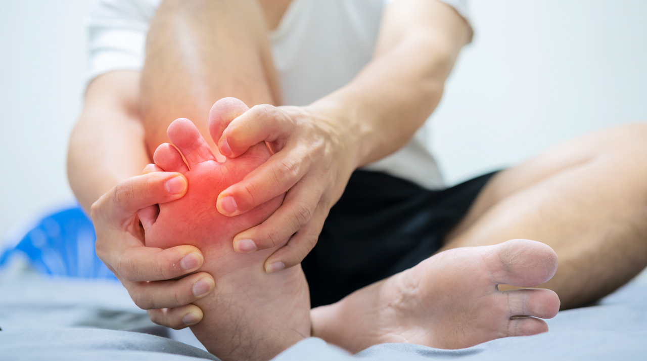 Young woman suffering from pain in foot.